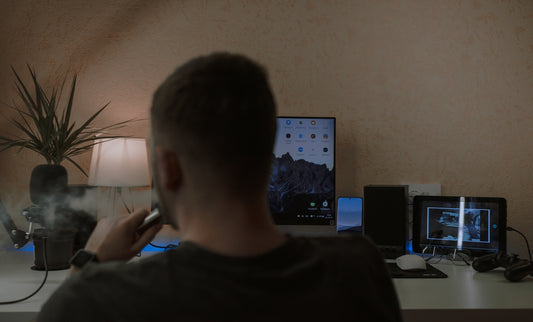 a man smoking a cigarette in front of a computer